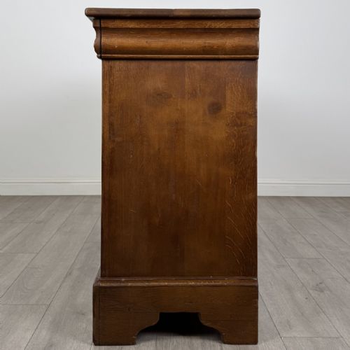 fig 2. An antique French oak sideboard featuring two top drawers above two panelled cupboard doors with carved floral details on the outer edges.