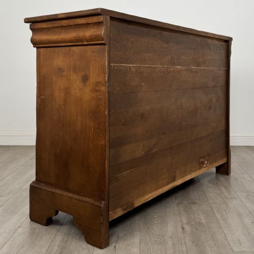 fig 3. An antique French oak sideboard featuring two top drawers above two panelled cupboard doors with carved floral details on the outer edges.