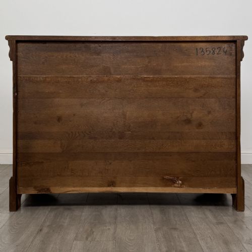 fig 4. An antique French oak sideboard featuring two top drawers above two panelled cupboard doors with carved floral details on the outer edges.