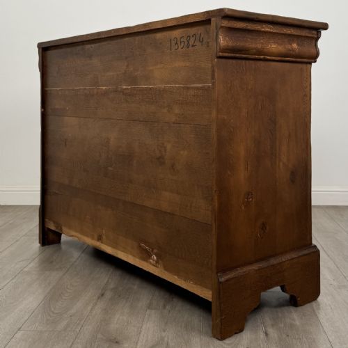 fig 5. An antique French oak sideboard featuring two top drawers above two panelled cupboard doors with carved floral details on the outer edges.
