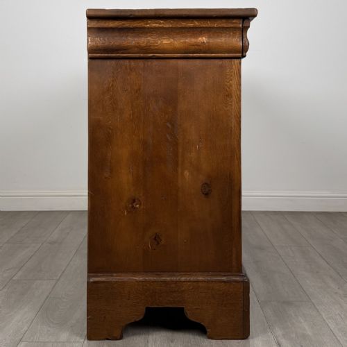 fig 6. An antique French oak sideboard featuring two top drawers above two panelled cupboard doors with carved floral details on the outer edges.