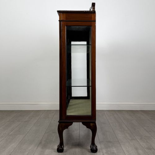 fig 2. A dark mahogany glazed display cabinet featuring gothic astragal door bars, a carved pediment top, and cabriole legs with ball and claw feet.