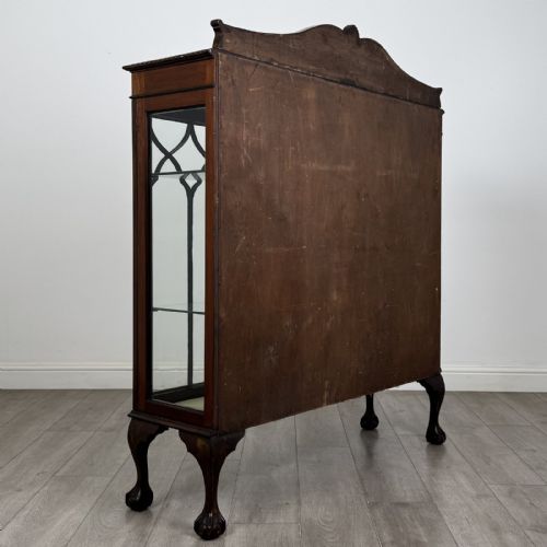 fig 3. A dark mahogany glazed display cabinet featuring gothic astragal door bars, a carved pediment top, and cabriole legs with ball and claw feet.
