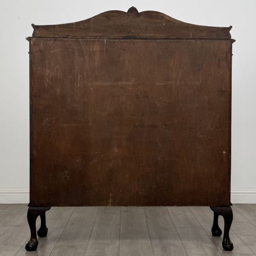 fig 4. A dark mahogany glazed display cabinet featuring gothic astragal door bars, a carved pediment top, and cabriole legs with ball and claw feet.