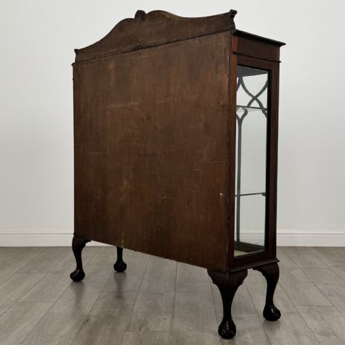 fig 5. A dark mahogany glazed display cabinet featuring gothic astragal door bars, a carved pediment top, and cabriole legs with ball and claw feet.