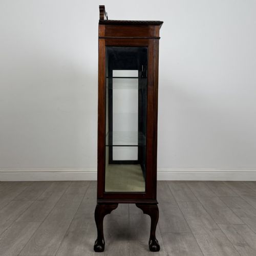 fig 6. A dark mahogany glazed display cabinet featuring gothic astragal door bars, a carved pediment top, and cabriole legs with ball and claw feet.