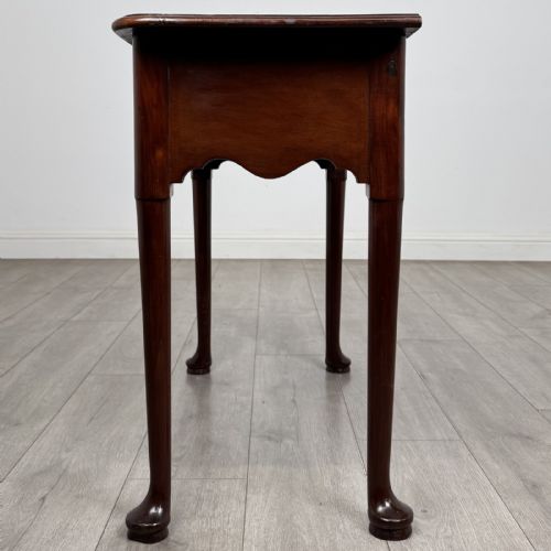 fig 2. An 18th-century Georgian mahogany side table featuring a single drawer with two brass swan-neck handles, a shaped frieze, and cabriole legs terminating in pad feet.