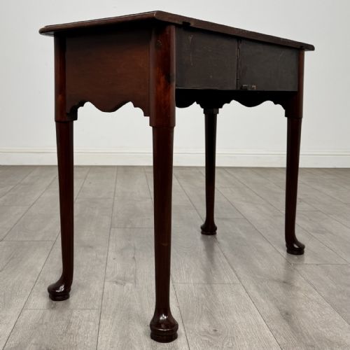 fig 3. An 18th-century Georgian mahogany side table featuring a single drawer with two brass swan-neck handles, a shaped frieze, and cabriole legs terminating in pad feet.