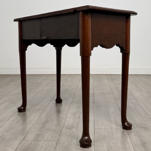 fig 5. An 18th-century Georgian mahogany side table featuring a single drawer with two brass swan-neck handles, a shaped frieze, and cabriole legs terminating in pad feet.
