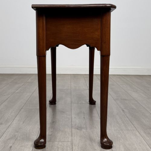 fig 6. An 18th-century Georgian mahogany side table featuring a single drawer with two brass swan-neck handles, a shaped frieze, and cabriole legs terminating in pad feet.