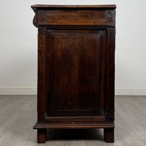 fig 2. A 19th-century French dark walnut sideboard featuring twin panelled doors with drop handles, flanked by fluted pilasters, with a carved winged cherub head centred on the frieze.