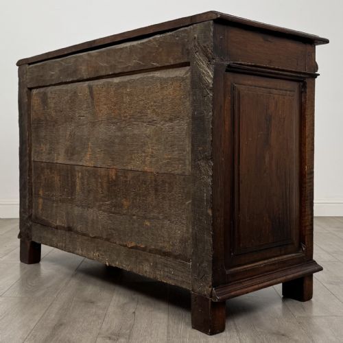fig 5. A 19th-century French dark walnut sideboard featuring twin panelled doors with drop handles, flanked by fluted pilasters, with a carved winged cherub head centred on the frieze.