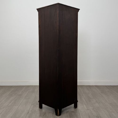 fig 1. A tall dark oak Jacobean style corner cabinet featuring an upper open section with an arched alcove and two shelves above a single panelled cupboard door.