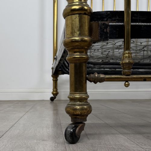 fig 6. A Victorian brass double bed frame with turned vertical spindles, spherical ball finials on the corner posts, and castors on the feet.