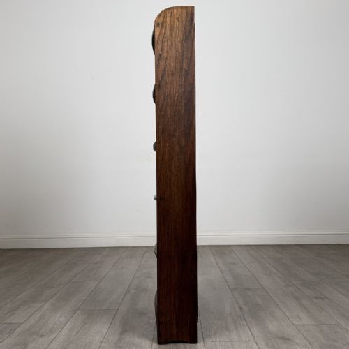 fig 2. A tall, narrow dark oak open bookcase featuring five bow-fronted shelves and a curved gallery top.