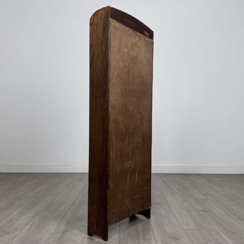 fig 3. A tall, narrow dark oak open bookcase featuring five bow-fronted shelves and a curved gallery top.