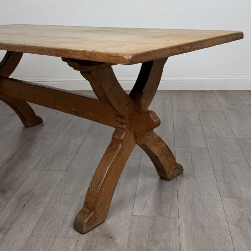 fig 3. A large 20th-century oak dining table featuring a rectangular wooden top supported by two trestle-style X-frame legs joined by a central horizontal stretcher.