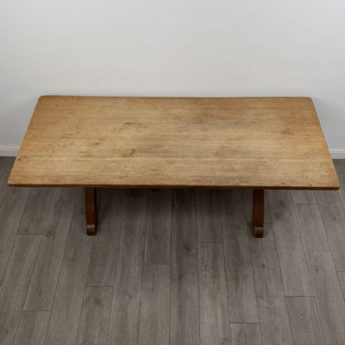 fig 4. A large 20th-century oak dining table featuring a rectangular wooden top supported by two trestle-style X-frame legs joined by a central horizontal stretcher.