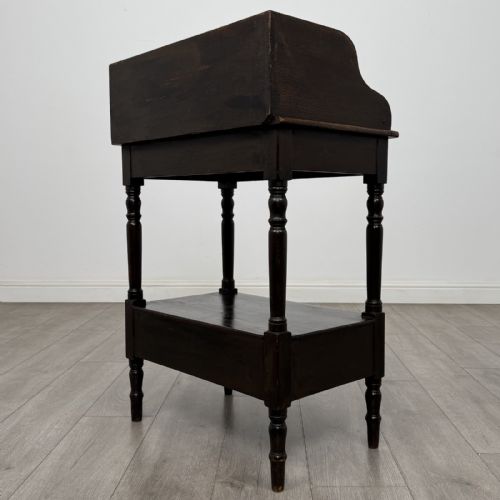 fig 5. A dark stained Victorian pine washstand featuring a three-quarter gallery back, turned legs, a lower shelf, and a base drawer with two turned wooden knobs.