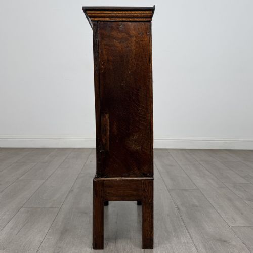 fig 2. A small dark Georgian oak spice cupboard on a stand with an arched fielded panel door and brass keyhole.