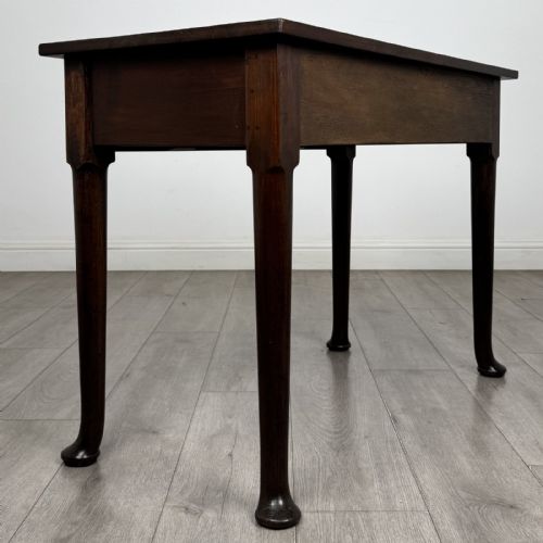 fig 3. A dark mahogany Georgian style side table featuring three drawers with ornamental brass handles and four tapered legs with pad feet.