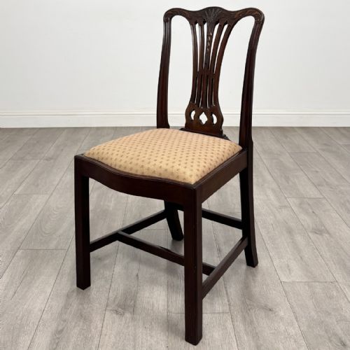 fig 1. A set of four dark mahogany dining chairs featuring carved pierced splats, straight square legs with H-stretchers, and patterned upholstered seats.