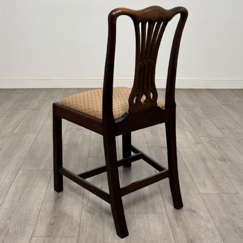 fig 2. A set of four dark mahogany dining chairs featuring carved pierced splats, straight square legs with H-stretchers, and patterned upholstered seats.