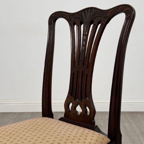 fig 3. A set of four dark mahogany dining chairs featuring carved pierced splats, straight square legs with H-stretchers, and patterned upholstered seats.