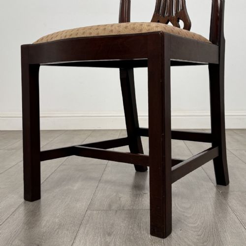 fig 4. A set of four dark mahogany dining chairs featuring carved pierced splats, straight square legs with H-stretchers, and patterned upholstered seats.