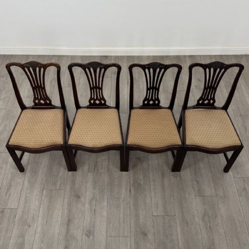 fig 6. A set of four dark mahogany dining chairs featuring carved pierced splats, straight square legs with H-stretchers, and patterned upholstered seats.