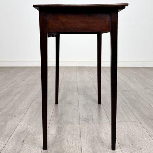 fig 2. An 18th-century Georgian mahogany side table with a single frieze drawer, brass handle, shaped apron, and straight square legs.
