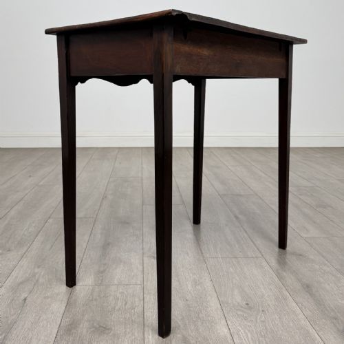 fig 3. An 18th-century Georgian mahogany side table with a single frieze drawer, brass handle, shaped apron, and straight square legs.