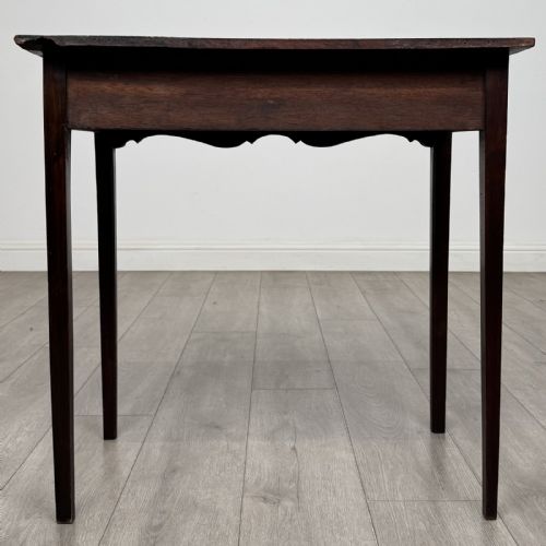 fig 4. An 18th-century Georgian mahogany side table with a single frieze drawer, brass handle, shaped apron, and straight square legs.