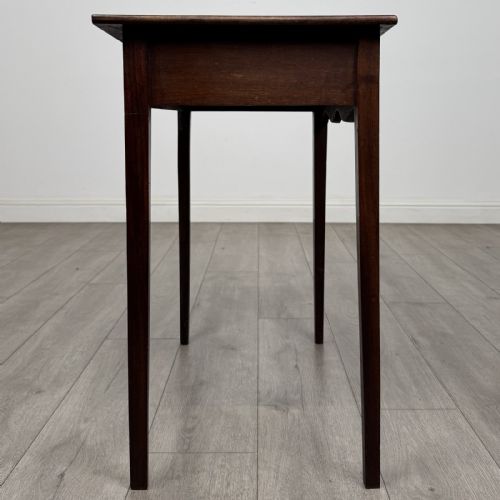 fig 6. An 18th-century Georgian mahogany side table with a single frieze drawer, brass handle, shaped apron, and straight square legs.