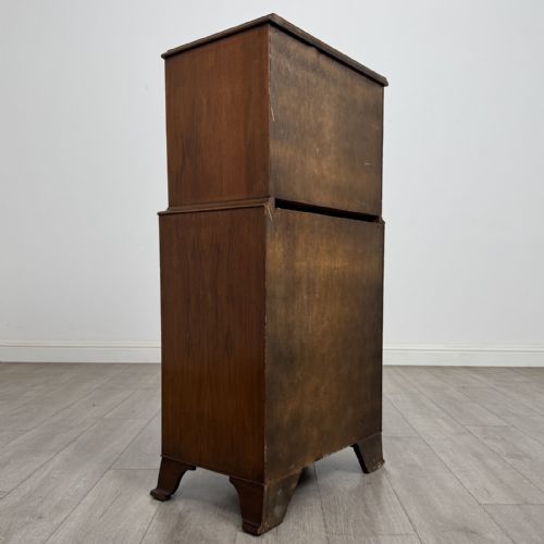 fig 3. A Georgian style burr walnut tallboy featuring a bow-front silhouette, seven stacked drawers with brass handles, and bracket feet.