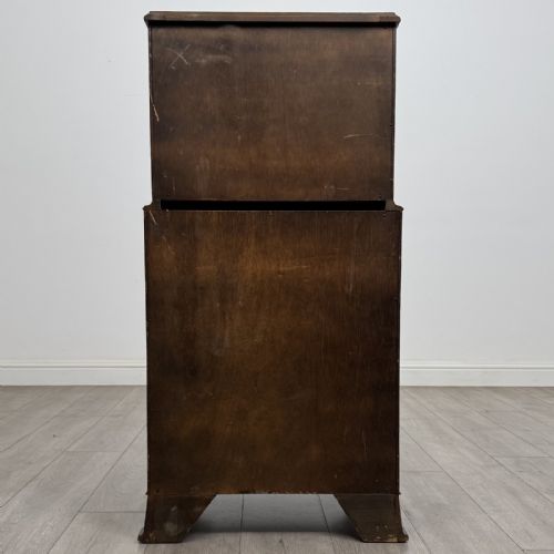fig 4. A Georgian style burr walnut tallboy featuring a bow-front silhouette, seven stacked drawers with brass handles, and bracket feet.