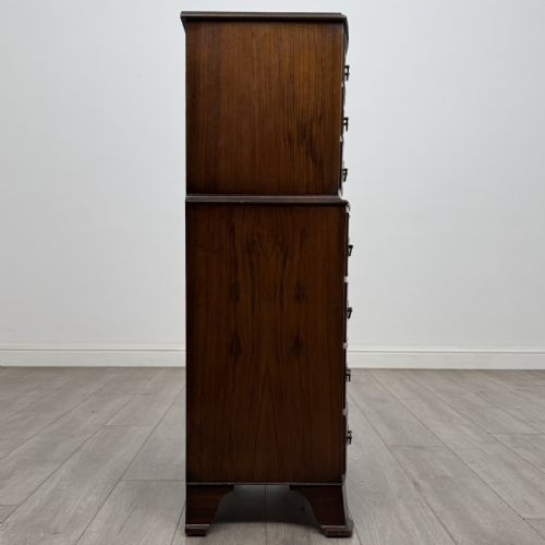 fig 6. A Georgian style burr walnut tallboy featuring a bow-front silhouette, seven stacked drawers with brass handles, and bracket feet.