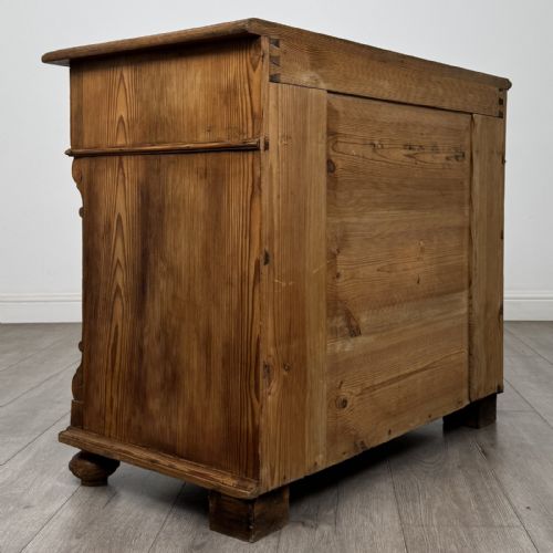 fig 3. An antique Victorian pine chest of four drawers featuring ornamental metal drop handles and carved architectural pilasters on turned feet.