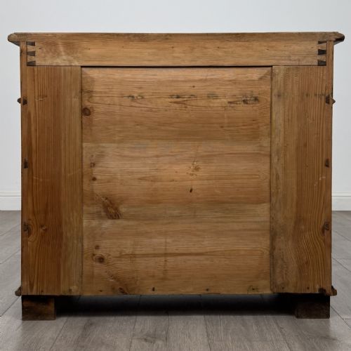 fig 4. An antique Victorian pine chest of four drawers featuring ornamental metal drop handles and carved architectural pilasters on turned feet.