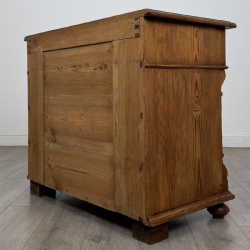 fig 5. An antique Victorian pine chest of four drawers featuring ornamental metal drop handles and carved architectural pilasters on turned feet.