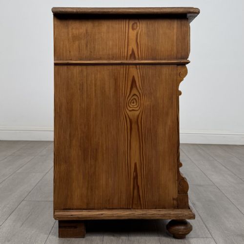 fig 6. An antique Victorian pine chest of four drawers featuring ornamental metal drop handles and carved architectural pilasters on turned feet.