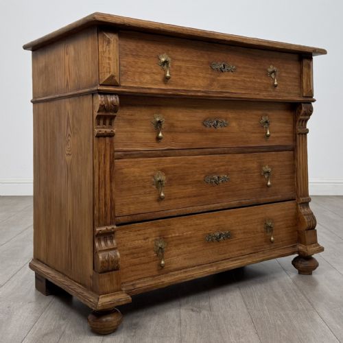fig 7. An antique Victorian pine chest of four drawers featuring ornamental metal drop handles and carved architectural pilasters on turned feet.