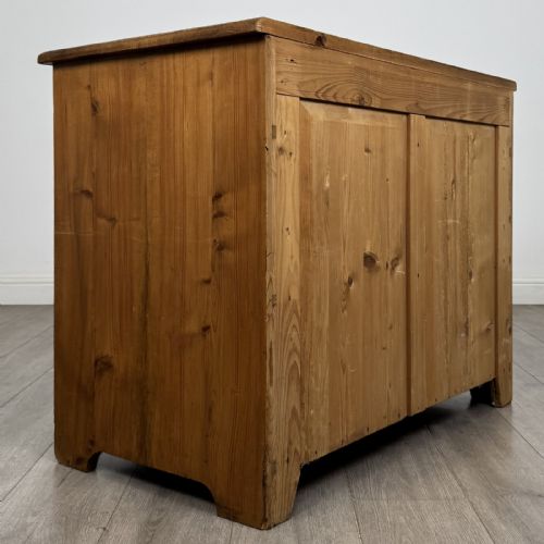 fig 3. A Victorian stripped pine cupboard featuring two top drawers with brass knobs above two panelled doors.