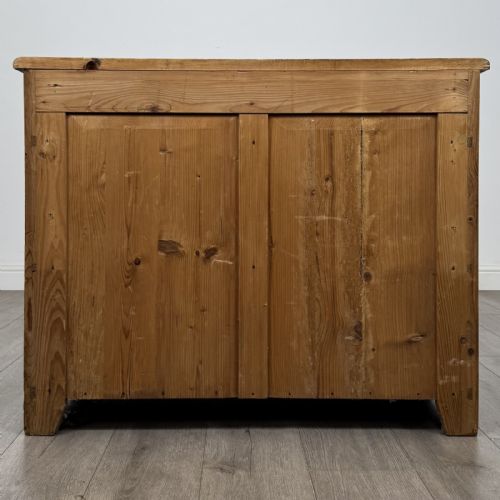 fig 4. A Victorian stripped pine cupboard featuring two top drawers with brass knobs above two panelled doors.