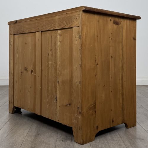 fig 5. A Victorian stripped pine cupboard featuring two top drawers with brass knobs above two panelled doors.