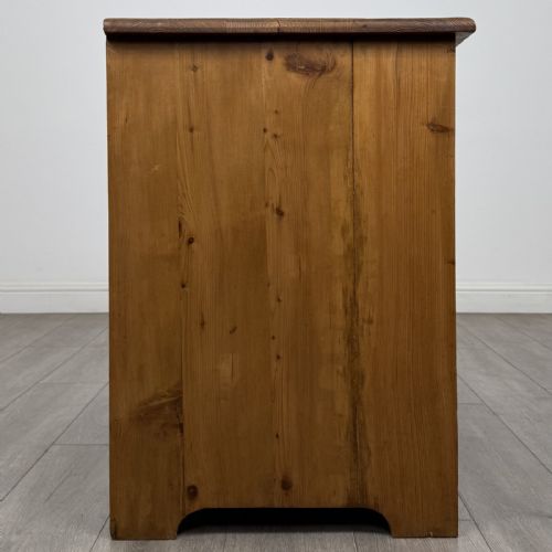 fig 6. A Victorian stripped pine cupboard featuring two top drawers with brass knobs above two panelled doors.