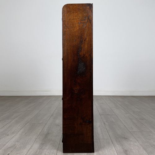 fig 1. An open dark oak bookcase featuring three shelves and a black iron cross back stretcher.