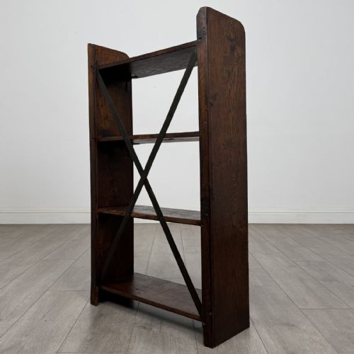 fig 4. An open dark oak bookcase featuring three shelves and a black iron cross back stretcher.