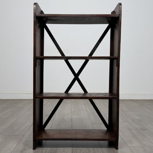 fig 8. An open dark oak bookcase featuring three shelves and a black iron cross back stretcher.