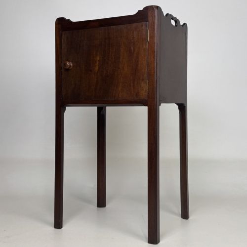 fig 1. A tall dark mahogany bedside cabinet featuring a gallery tray top, single cupboard door, and square legs.